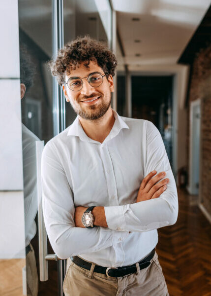 Young smiling well dressed businessman posing for a shot at the office